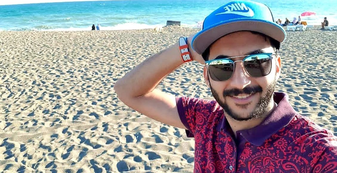 صورة لمصطفى جمال على أحد الشواطئ مرتديا نظارة شمسية.