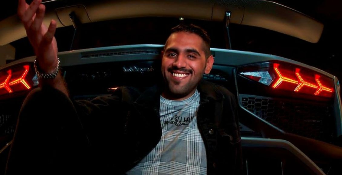 صورة تظهر عبدالله النعيمي يجلس وخلفه سيارة.