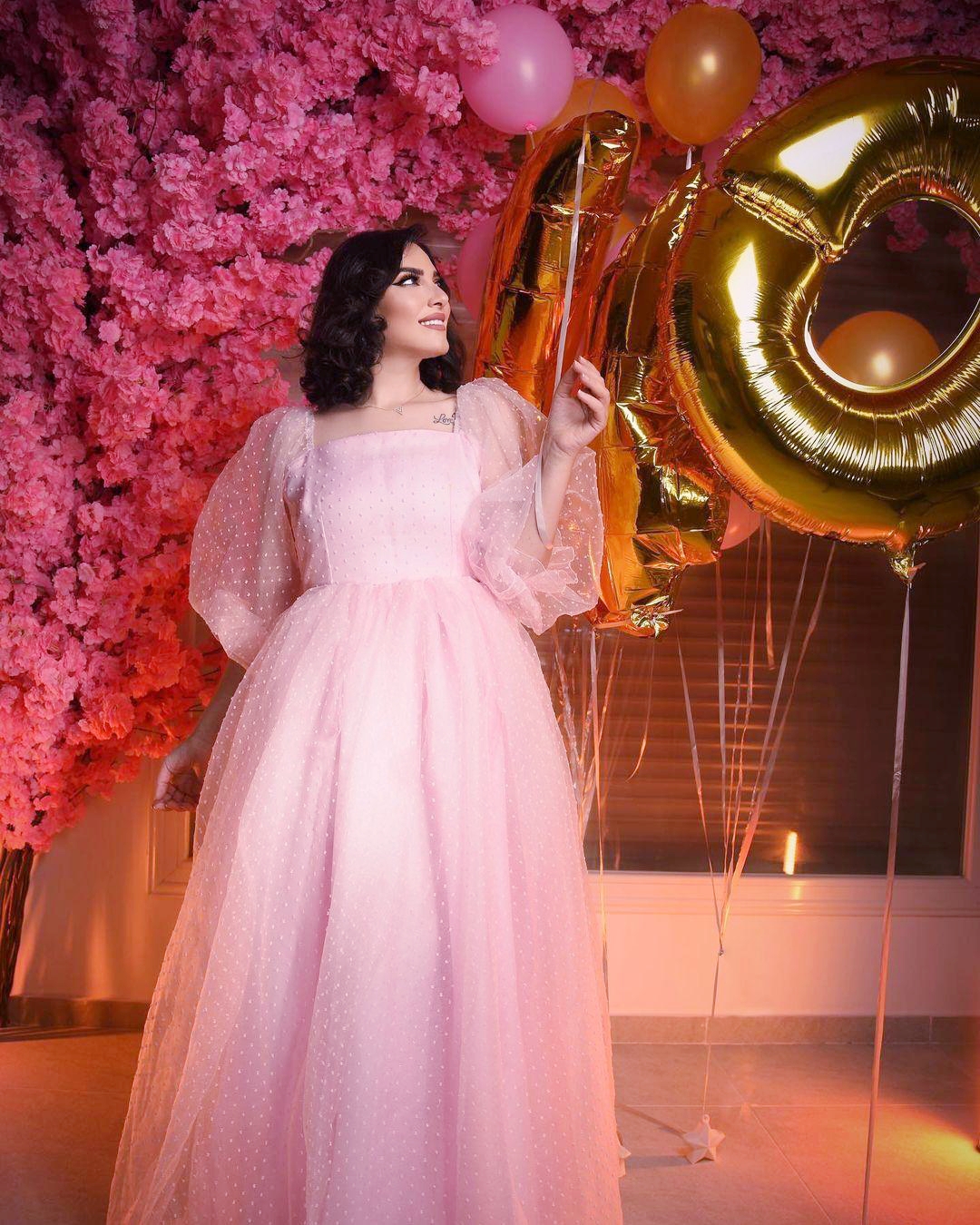 هبة الدري تحتفل بعيد ميلادها مرتدية ثوباً وردياً وخلفها رقم 40 والكثير من الورود 
