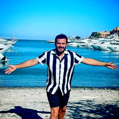 صبحي عطري بلوك صيفي مميز من أمام شاطئ الجونة ومراكبه بشورط أسود وقميص مقلم