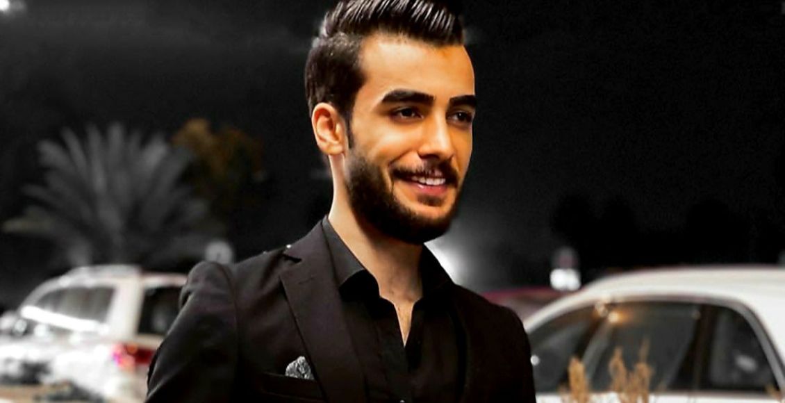 احمد قيمز مرتدياً بدلة سوداء.