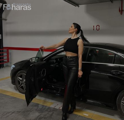 سوسن المصمودي في صورة بجانب سيارة سوداء وهي ترتدي ملابس باللون الأسود